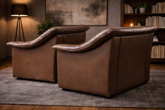 Image 1 of Pair of mid‑century brown leather club armchairs in good condition with small signs of aging and blemishes