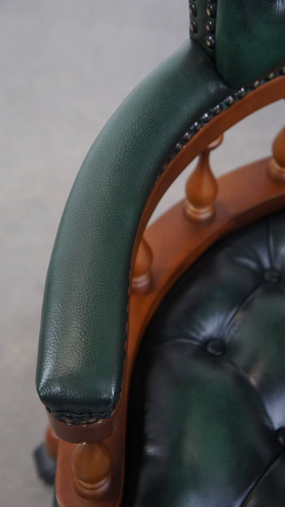 Image 1 of Rundleren en houten donkergroene chesterfield bureaustoel op wieltjes