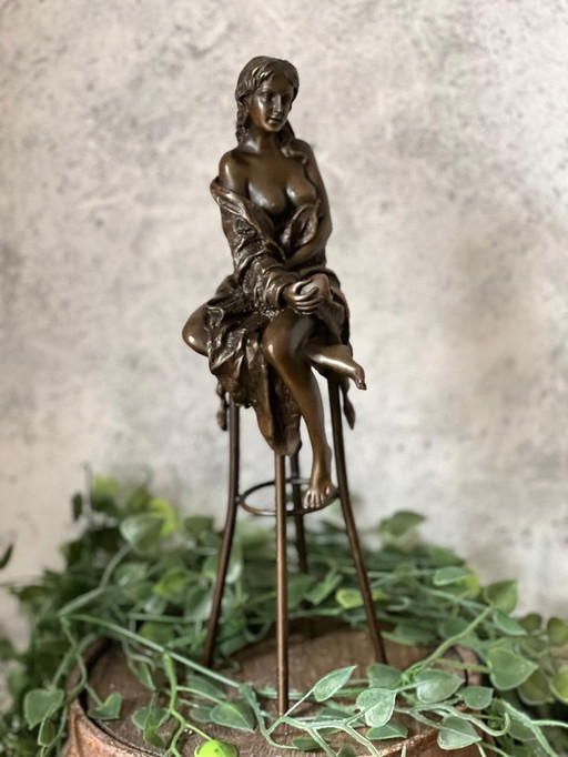 Bronzestatue einer Dame auf einem Stuhl mit einem Apfel