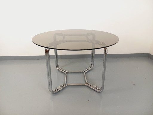 Round vintage dining table in smoked glass and chromed metal in the Space Age style of the 70s
