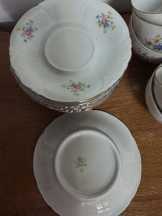 Image 1 of 11 tazze e 9 piattini vintage in porcellana bianca con decorazioni floreali, risalenti al XX secolo e numerati.