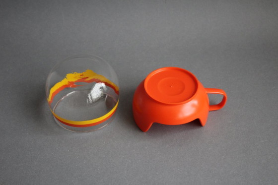 Image 1 of 12 vintage glazen theekopjes met geel-oranje strepen en oranje plastic houders.