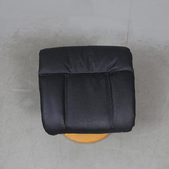Image 1 of Sweden-origin Scandinavian lounge armchair with a matching ottoman, featuring a black leather and wood frame, in good condition 