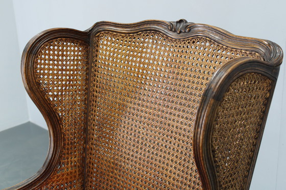 Image 1 of Ancienne chaise à oreilles sculptée avec côtés en canne, Tchécoslovaquie