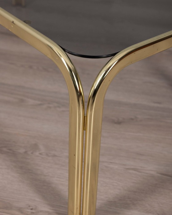 Image 1 of Vintage salontafel uit de jaren 70 in Italiaans design, uitgevoerd in verguld messing en rookglas.