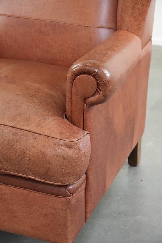 Image 1 of Poltrona a orecchioni color cognac chiaro, rivestita in pelle bovina, dal caratteristico look inglese.