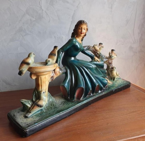 Image 1 of Un grand bâtiment Art-déco datant de début 1900 avec des femmes et des animaux.