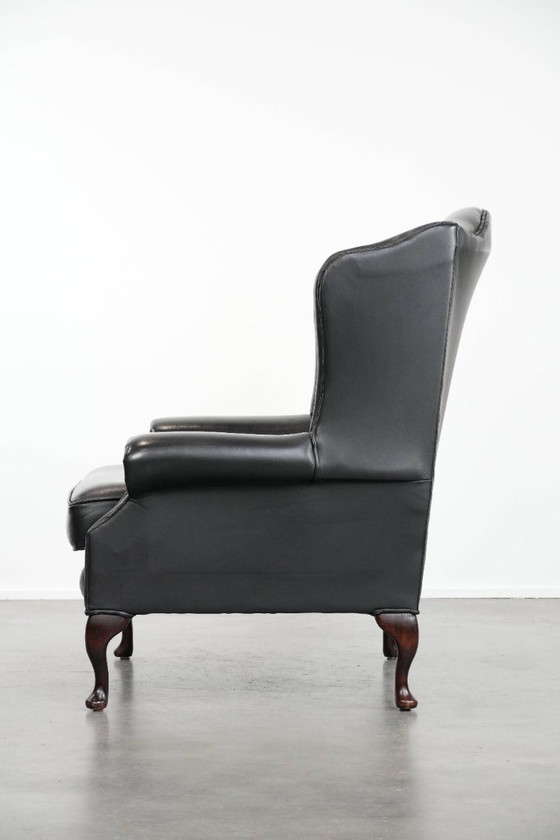 Image 1 of Smooth black cowhide Chesterfield wingback armchair in English style with color-matched piping