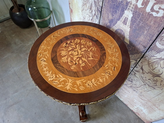 Image 1 of Mesa central redonda clásica de chapa de nogal con marquetería, base ornamentada y herrajes de latón.