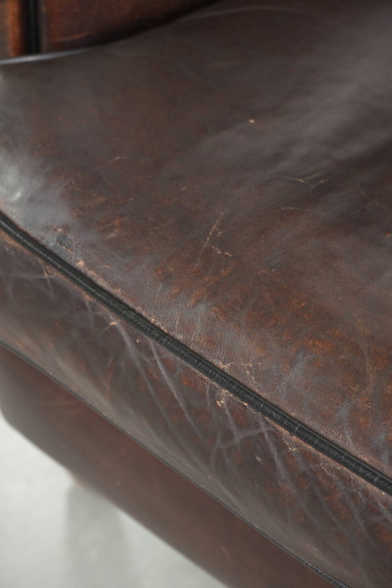 Image 1 of Dark sheepskin club armchair with a unique design and a desirable English-style patina.