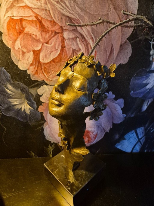 Statue en bronze de visage de femme avec des papillons et des fleurs