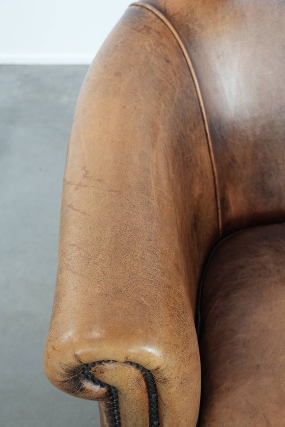 Image 1 of Clubfauteuil gemaakt van schapenleer afgewerkt met siernagels