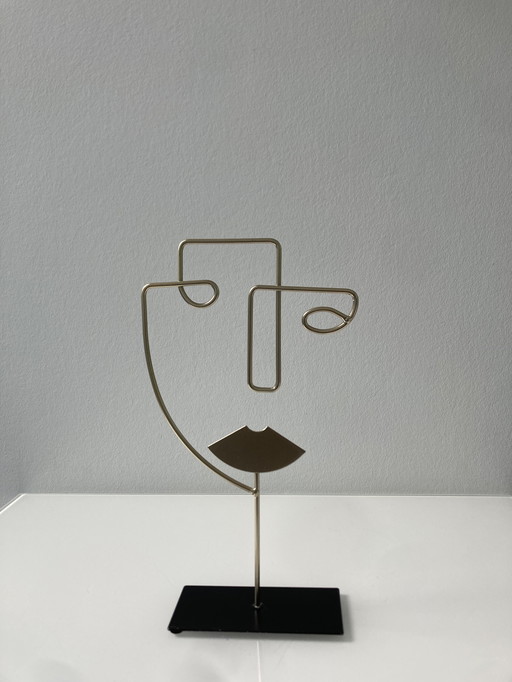 Sculpture moderne en fil de fer représentant un visage stylisé