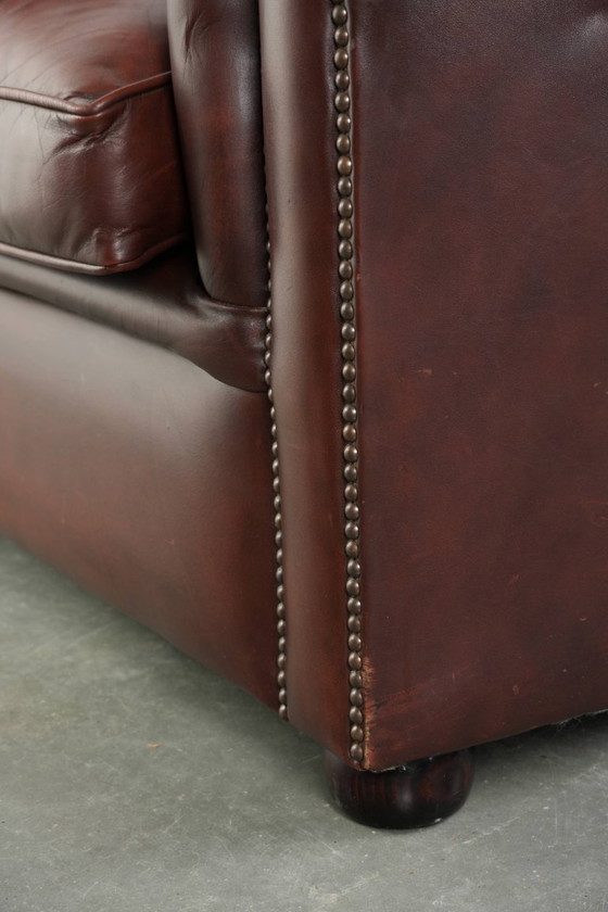 Image 1 of Beautiful red/brown cowhide Chesterfield armchair in a classic English style