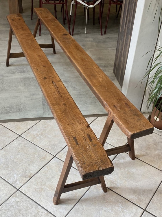 Image 1 of Twee massief eikenhouten boerenbanken van 214 cm voor een rustieke boerentafel uit de jaren 50.