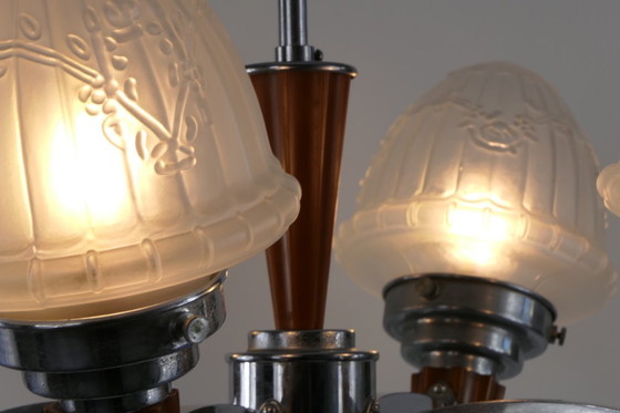 Image 1 of Chrome Art Deco chandelier with four amber Bakelite torches with decorated glass lampshades, ca. 1935