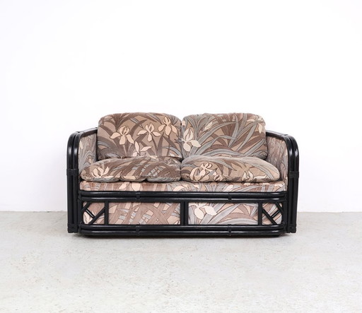 Banco vintage de bambú con tela de terciopelo floral.