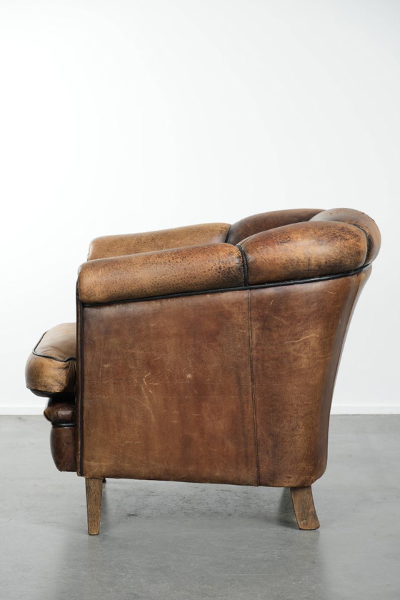 Image 1 of Leuke vintage schapenleren clubfauteuil in Engelse stijl met zwarte biezen