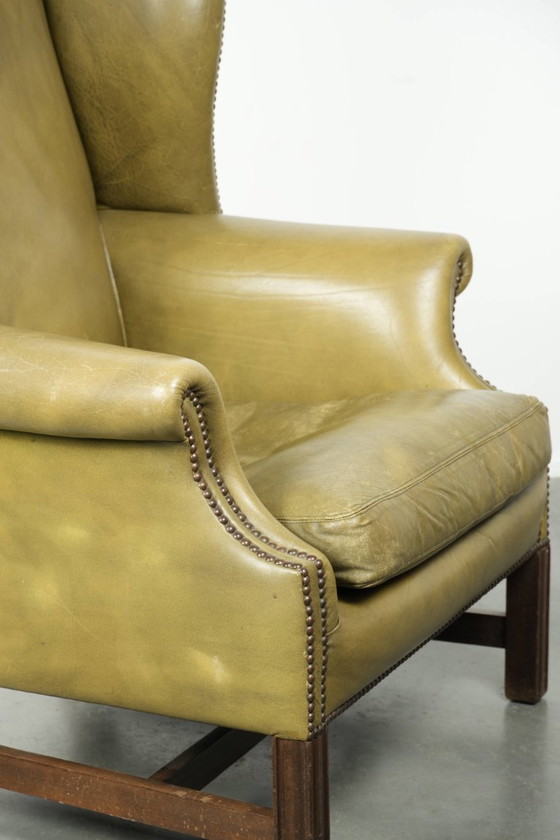 Image 1 of Fauteuil à oreilles ancien et élégant en cuir de vachette vert, de style classique de maison de campagne anglaise.