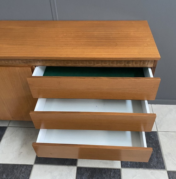 Image 1 of Dressoir uit de jaren 70 met decoratieve lijn boven de deuren.