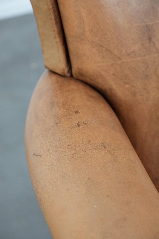 Image 1 of Fauteuil vintage discret en peau de mouton aux pieds gracieux