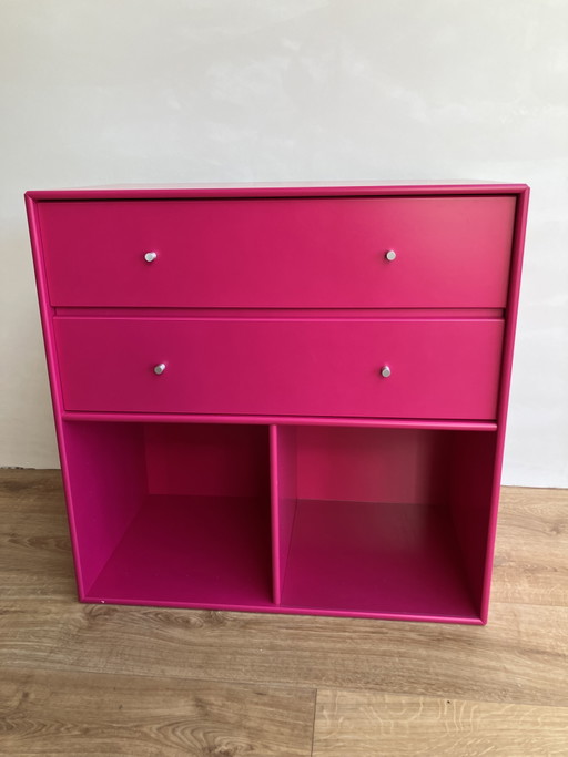 Módulo de muebles original Montana con cajones y compartimentos abiertos en color rosa fucsia.