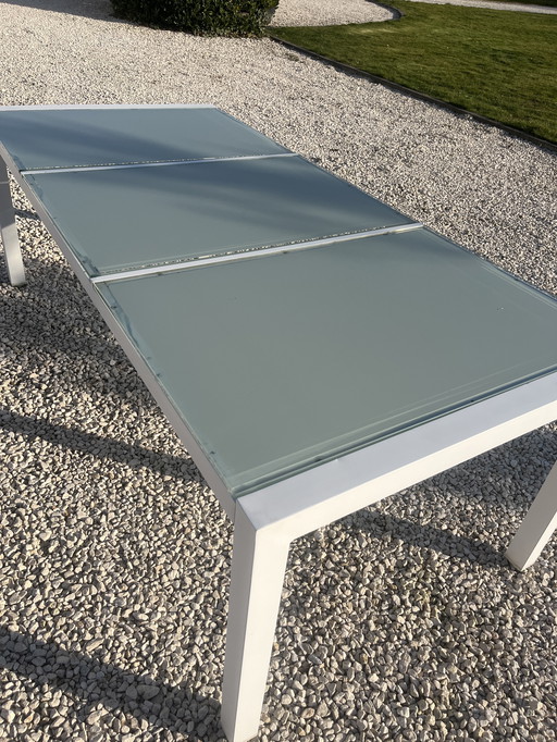 Bellissimo tavolo da giardino di design con piano in vetro satinato.