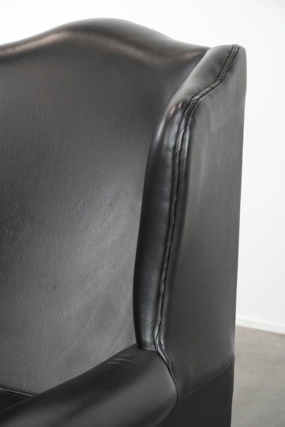 Image 1 of Smooth black cowhide Chesterfield wingback armchair in English style with color-matched piping
