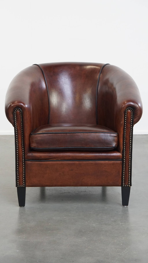 Fauteuil club en peau de mouton avec passepoil noir