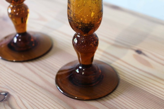 Image 1 of Een paar BIOT kaarsenstandaards van amberkleurig glas.