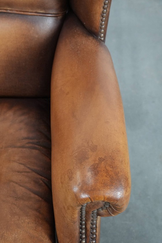 Image 1 of Sillón orejero de piel de oveja acabado con clavos decorativos