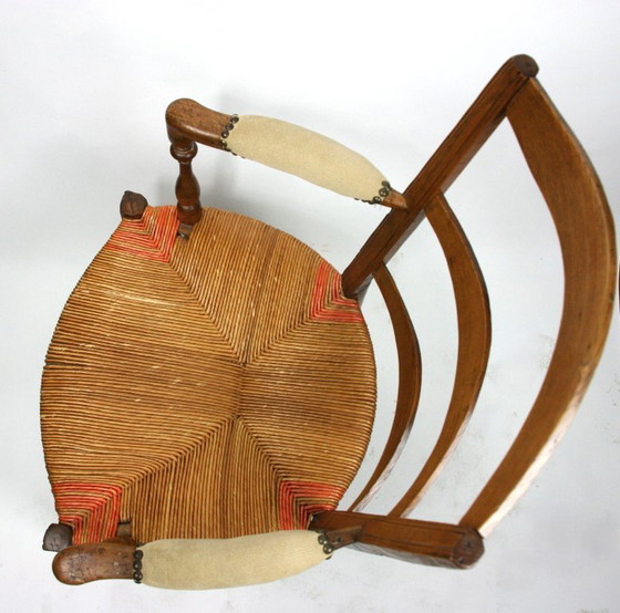 Image 1 of Antieke Frans-Provençaalse armstoel met biezenmat zitting — notenhout, gedraaide accenten, circa late 19e/vroeg 20e eeuw