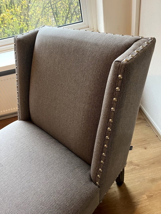 Image 1 of Le fauteuil Columbia d'Eichholtz, un fauteuil lounge design orné de clous décoratifs.