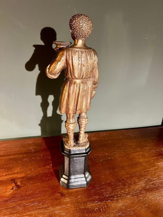 Image 1 of Rarität! Kerzenständer mit der Abbildung eines orientalischen Jünglings aus Messing auf schwarzem Porzellanfuß, 20. Jahrhundert 