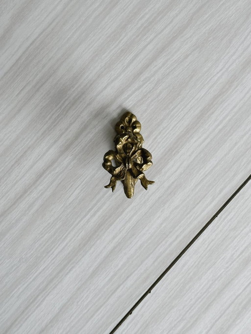 Small coat hook in gilded metal with bow motif