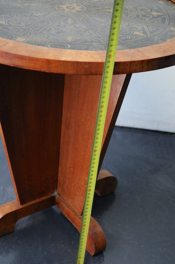 Image 1 of Una mesa para fumar Art Decó con una tapa de latón decorada.