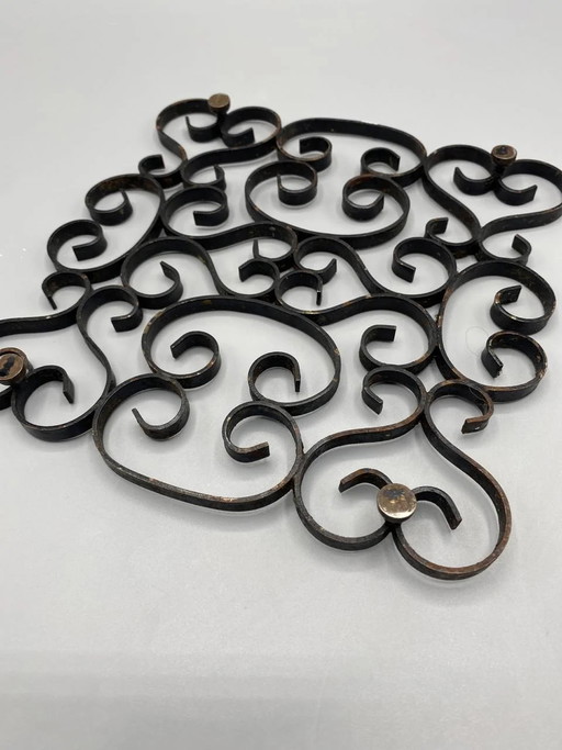 Sottopentola in ferro battuto lavorato a mano con decorazioni a volute e arabeschi, forma quadrata (photo 2 of 3)