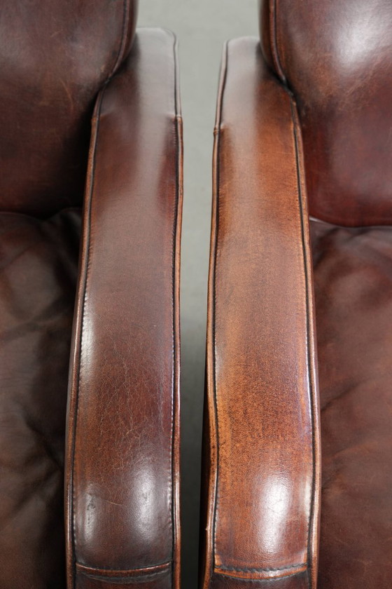 Image 1 of 2x dunkel cognacfarbene Schaffellsessel mit abgerundeten Formen und elegantem Design