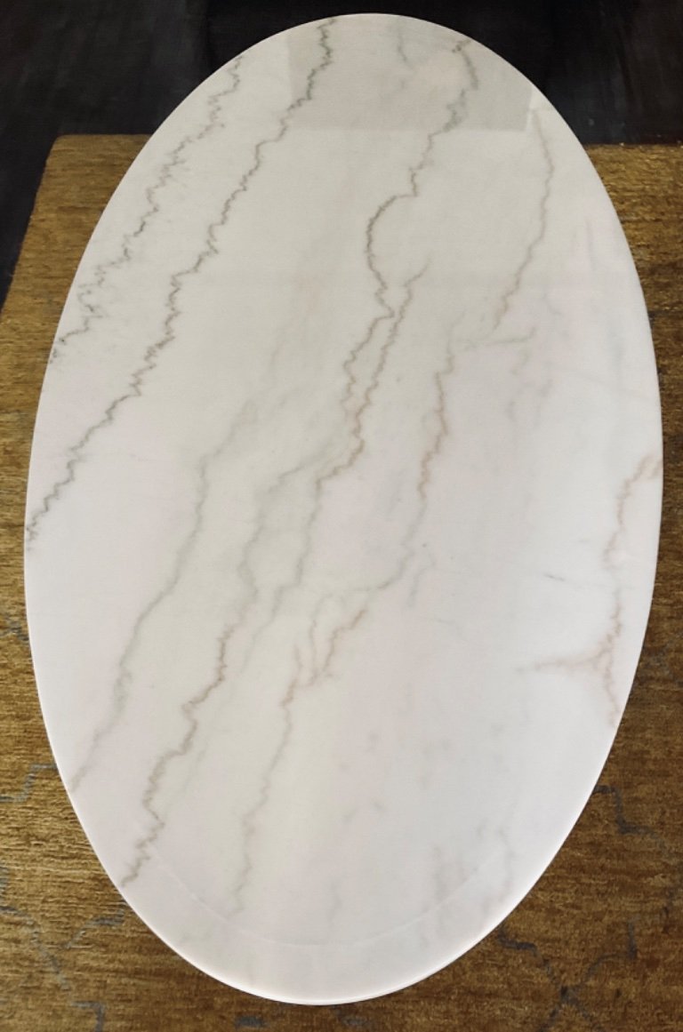 Mesa ovalada de mármol blanco.