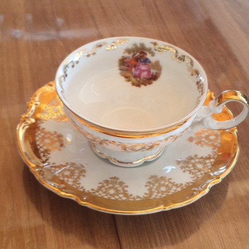 Tasse et soucoupe en porcelaine dorée – décor romantique