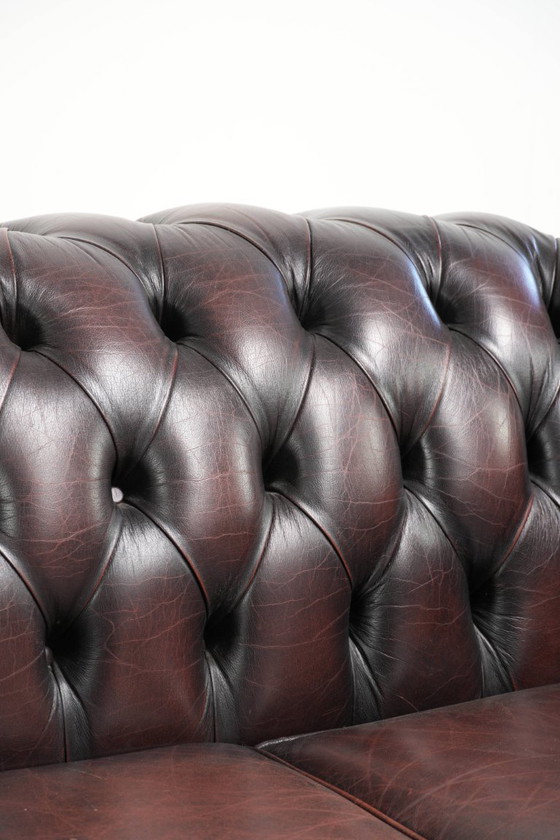 Image 1 of Canapé Chesterfield 2 places en cuir de vachette anglais ancien rouge/marron, au style magnifique et au charme intemporel.