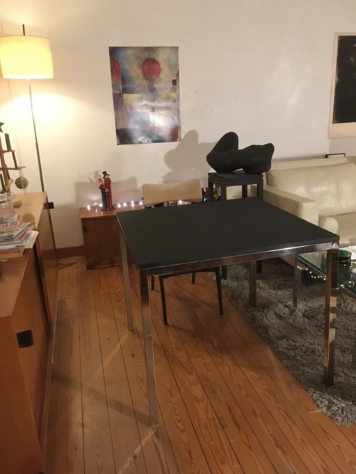 Modern dining table with chrome frame and black wood top