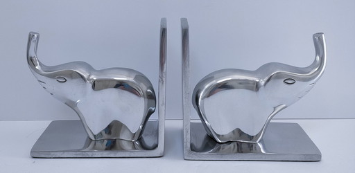 een paar boekensteunen in de vorm van olifanten, gegoten aluminium