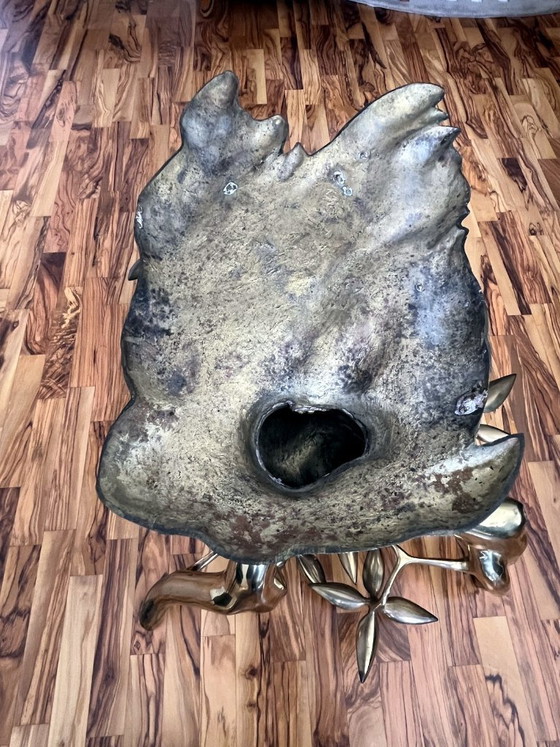 Image 1 of Sculpturale salontafel in de vorm van een boom, gemaakt van gegoten metaal, met een ovaal glazen blad.