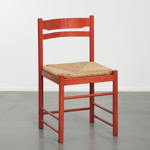 Sedia vintage in legno rosso degli anni '70 con seduta in canna intrecciata.
