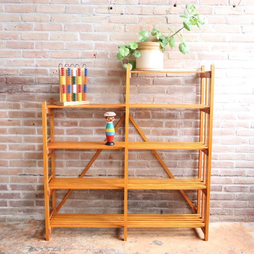 Estantería vintage con puertas de listones abiertos, ideal para juguetes y libros.