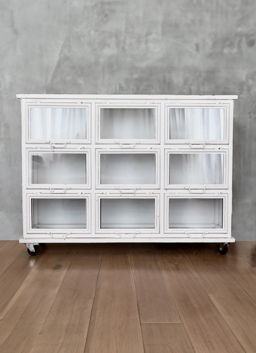 Vintage metal display case with 9 glass swinging doors.
