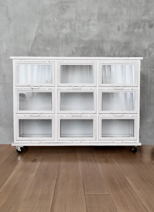 Vintage metal display case with 9 glass swinging doors.