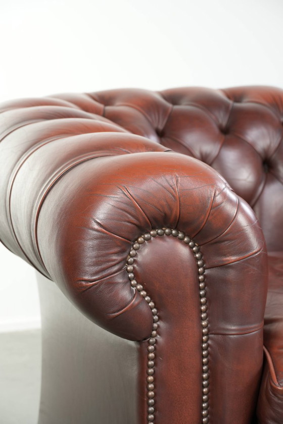 Image 1 of Beautiful red/brown cowhide Chesterfield armchair in a classic English style