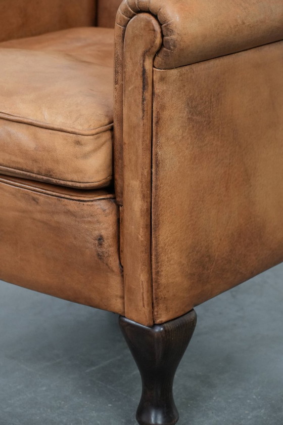 Image 1 of Fauteuil vintage discret en peau de mouton aux pieds gracieux